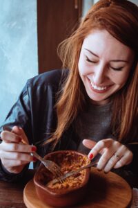ine rothaarige Frau isst gerade einen Eintopf. Die Nordische Küche ist vielfältig und gesund (nordic cuisine)